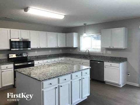 a kitchen with white cabinets and a granite counter top