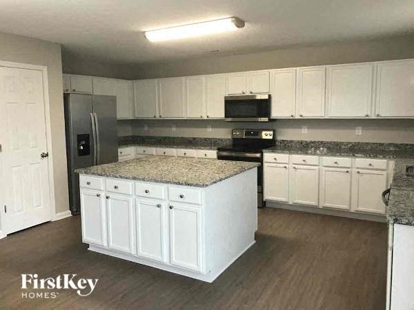 a kitchen with white cabinets and granite counter tops