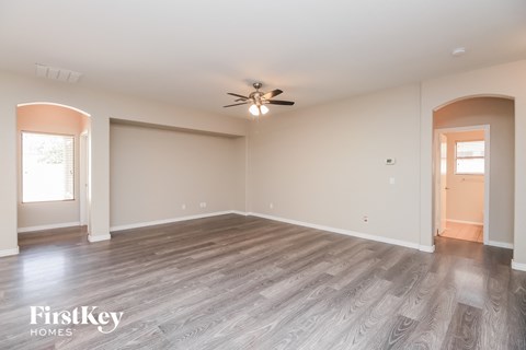 the living room of an empty house with a ceiling fan