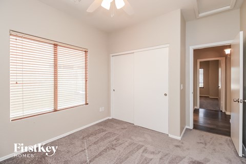 a bedroom with a large window and a door to a hallway