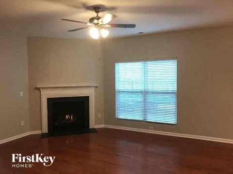 a living room with a fireplace and a ceiling fan