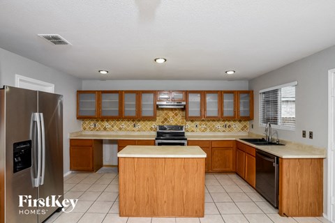 a kitchen with wooden cabinets and a stainless steel refrigerator