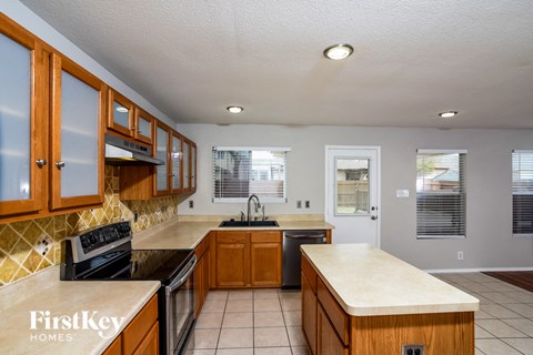 a kitchen with wooden cabinets and a stove and a sink