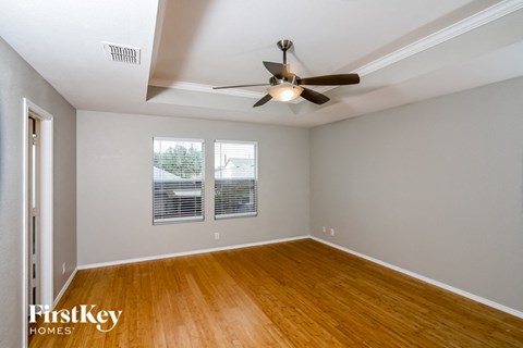 an empty living room with a ceiling fan and a window