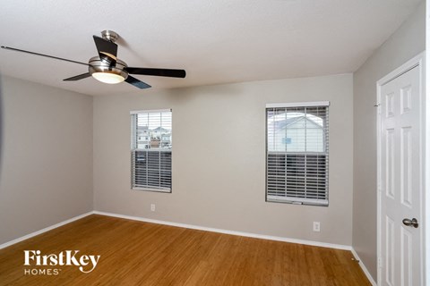 an empty room with a ceiling fan and a window