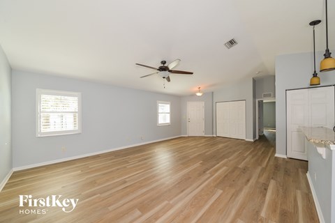 a living room with wood floors and a ceiling fan