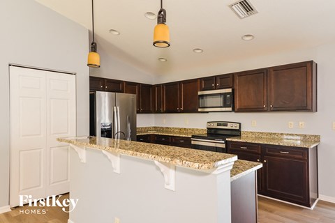 a kitchen with granite counter tops and wooden cabinets