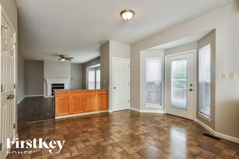 A spacious living room with a fireplace and a ceiling fan.