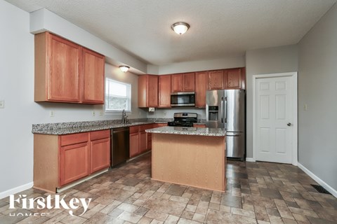 A kitchen with brown cabinets and a granite counter top.
