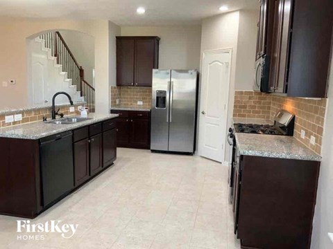 a kitchen with a stainless steel refrigerator and a sink