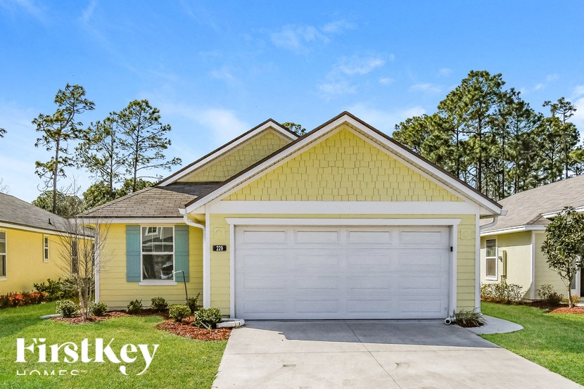 A yellow house with a white garage door in front.