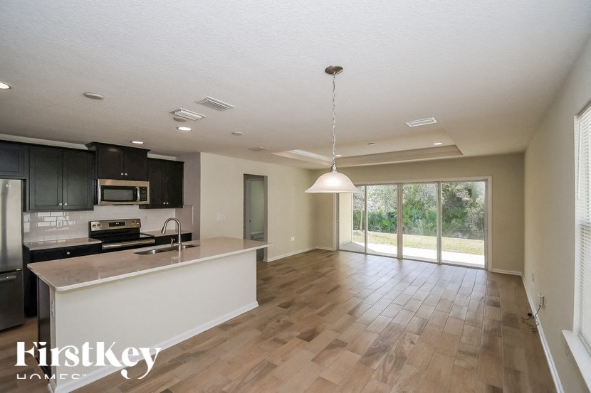 A kitchen with a white island and a hanging light fixture.