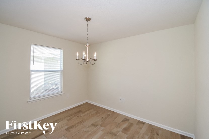 A room with a chandelier and a window.