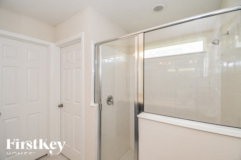 A white door with a glass shower stall in the bathroom.
