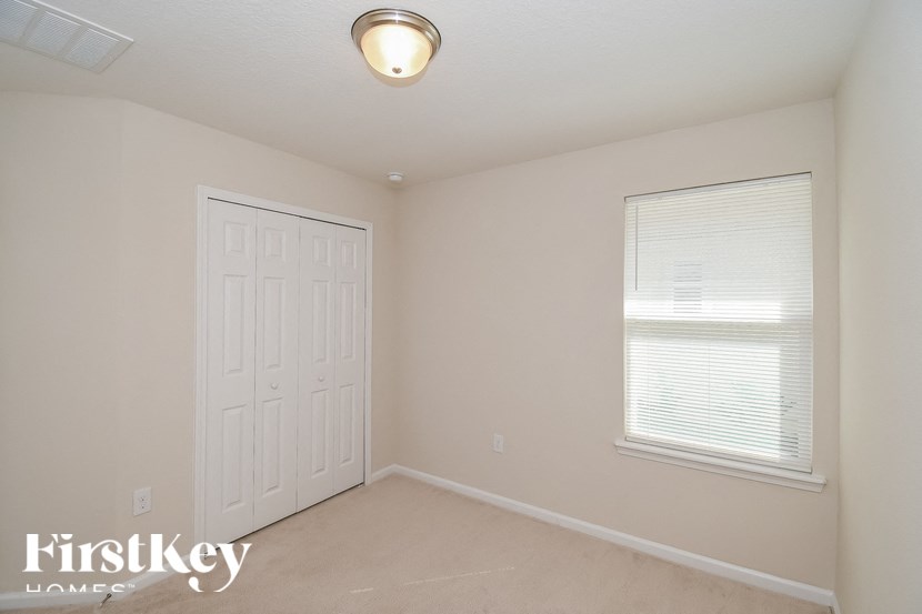 A room with a white door and a window with blinds.