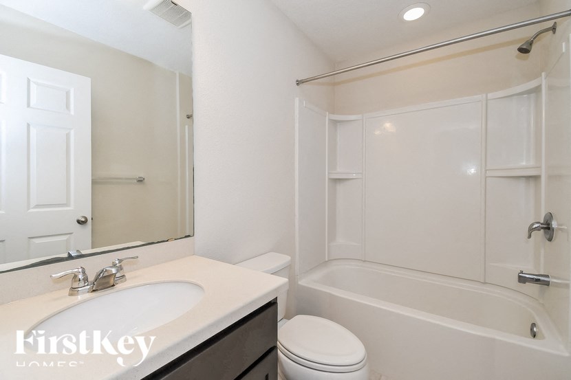 A white bathroom with a toilet, sink, and bathtub.