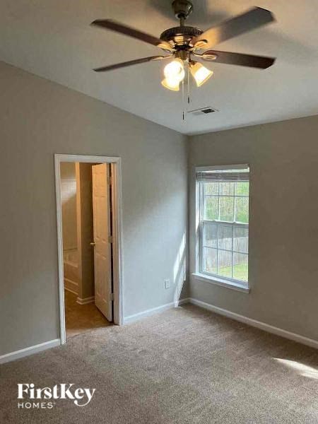 an empty room with a ceiling fan and a window
