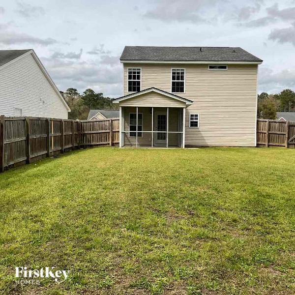 a backyard with a house and a fence