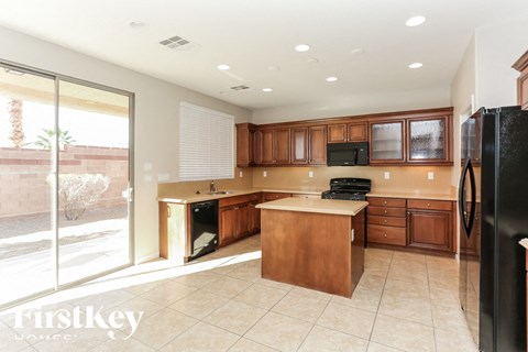 A kitchen with wooden cabinets and a black refrigerator.