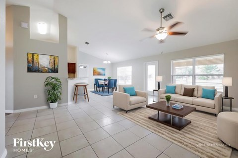 A spacious living room with a large couch, a coffee table, and a painting on the wall.