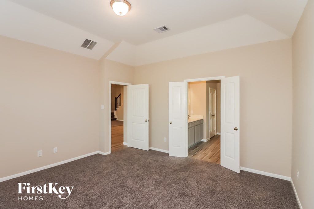 A room with a carpeted floor and two open doors.