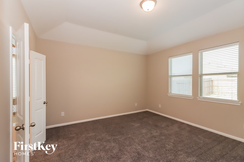 A room with a carpeted floor and a door on the left.