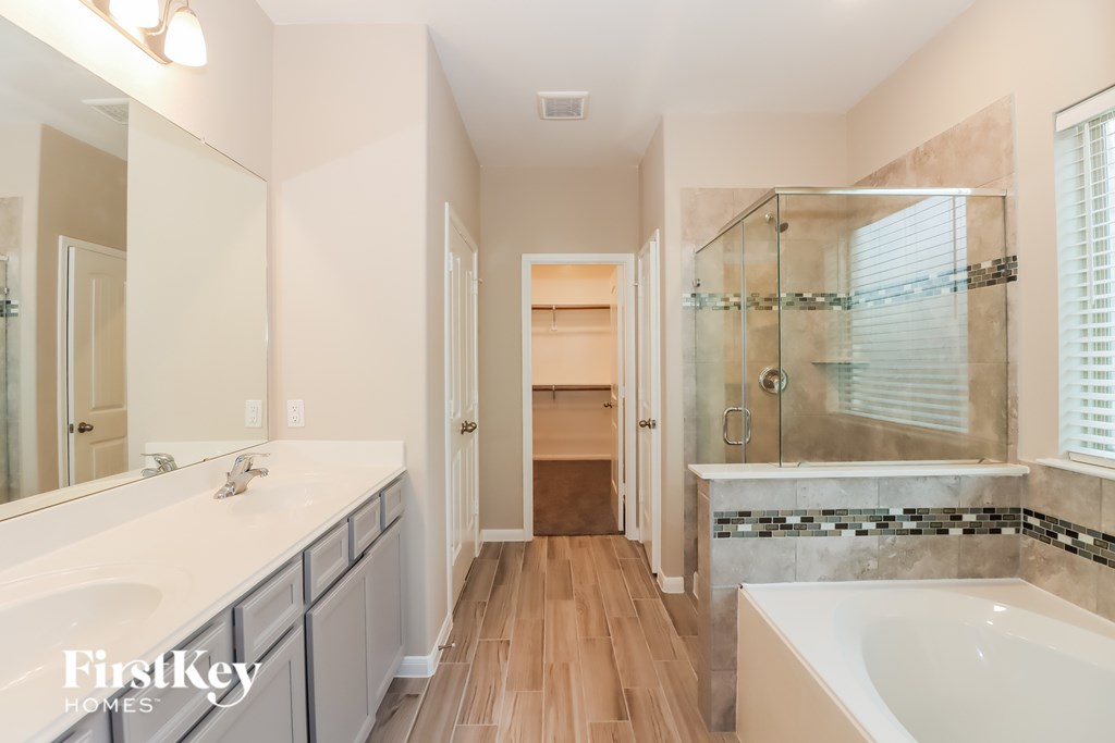 A bathroom with a white tub and a walk in shower.