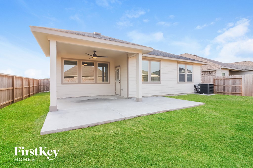 A white house with a patio and a ceiling fan.