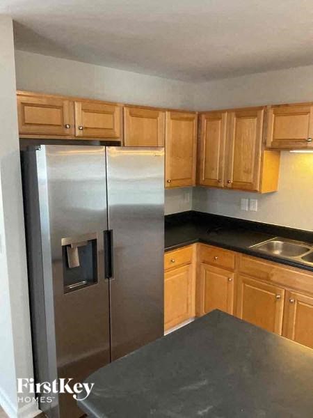 a kitchen with a stainless steel refrigerator and wooden cabinets