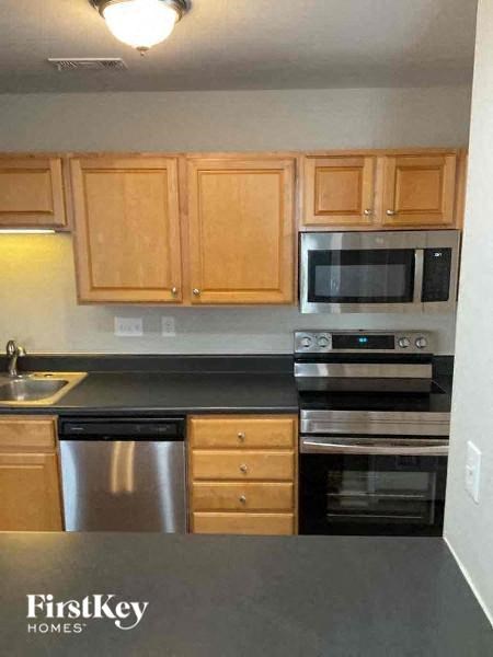 a kitchen with wooden cabinets and a black counter top