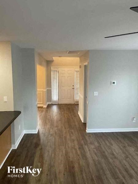an empty living room with wood floors and a white door