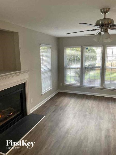 a living room with a fireplace and a ceiling fan