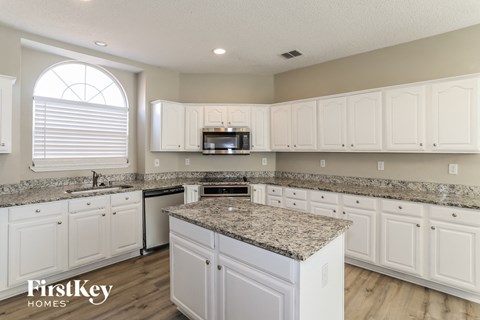 a kitchen with white cabinets and granite counter tops