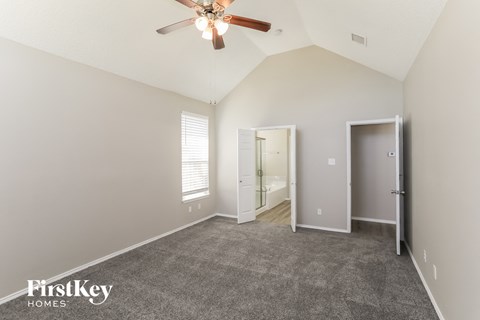 a living room with carpet and a ceiling fan