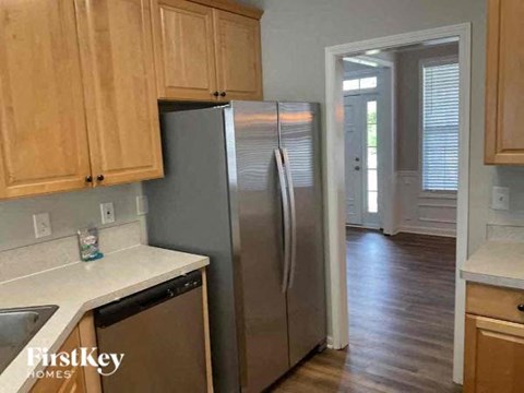A kitchen with wooden cabinets and a stainless steel refrigerator.