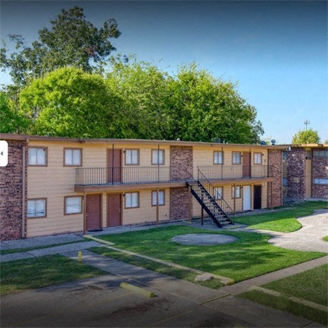 an apartment building with a yard and a staircase