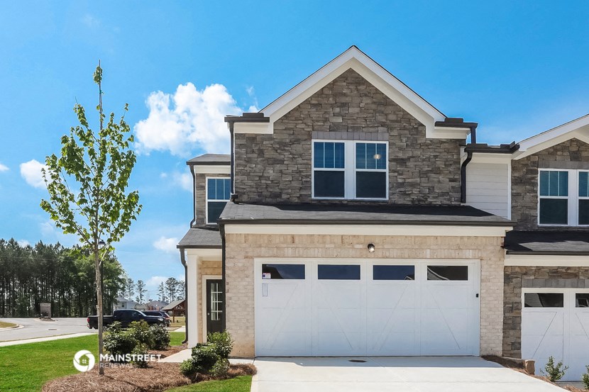 a brick house with a white garage door in front of it