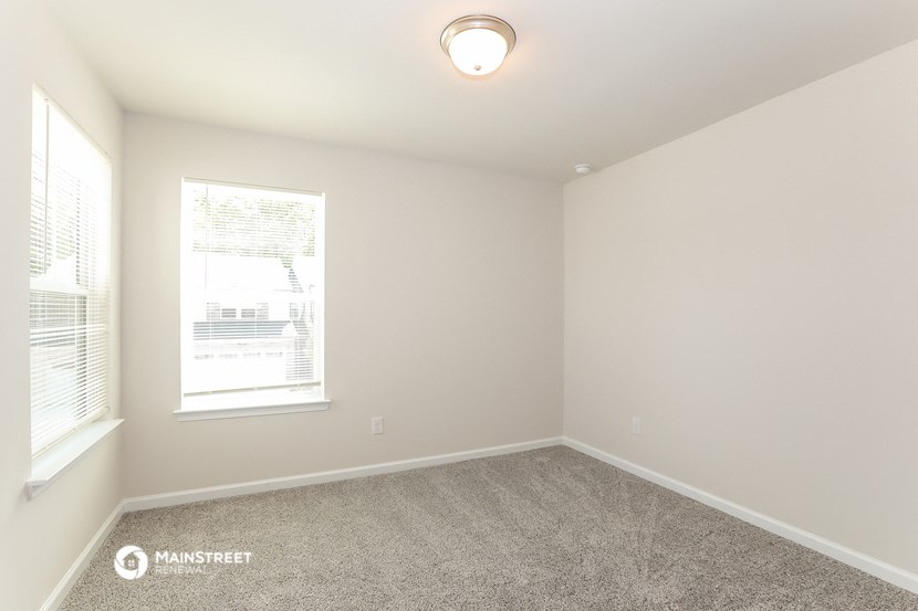 an empty room with carpet and a window