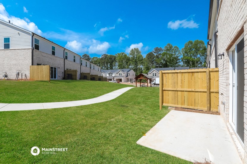 the backyard of a house with a yard and a wooden fence