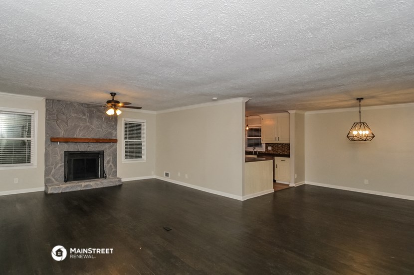 the living room and kitchen of a house with a fireplace