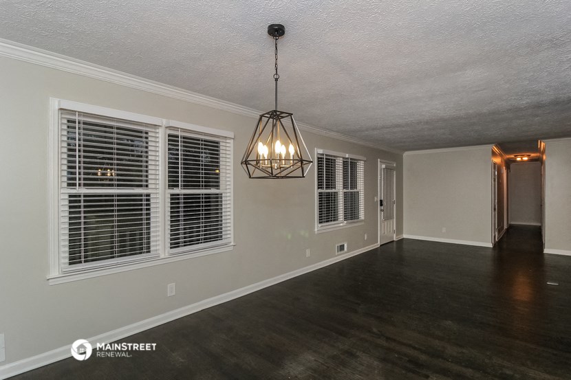 the living room of a house with a large window and a chandelier