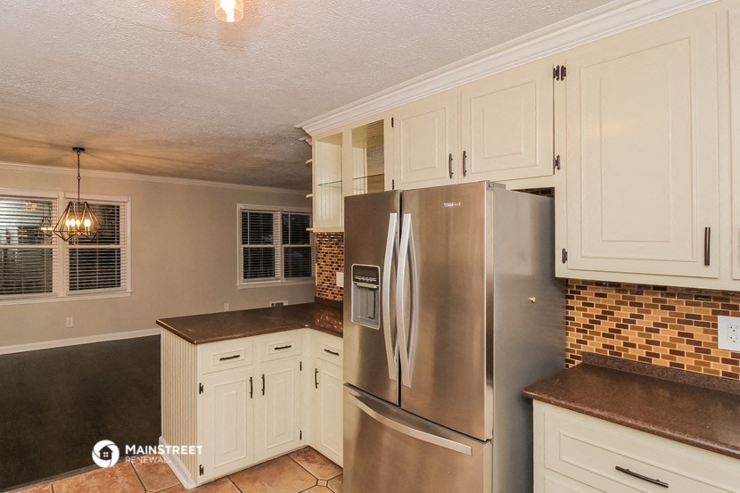 a kitchen with a stainless steel refrigerator and white cabinets