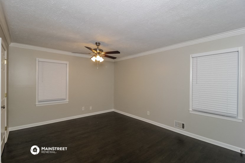 the living room of an empty house with a ceiling fan