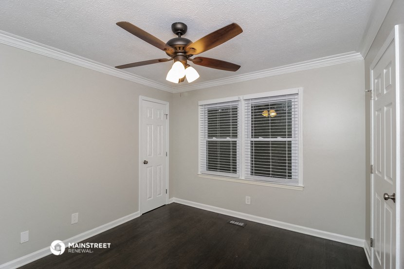 the bedroom of the bridgewater house has a ceiling fan and a window