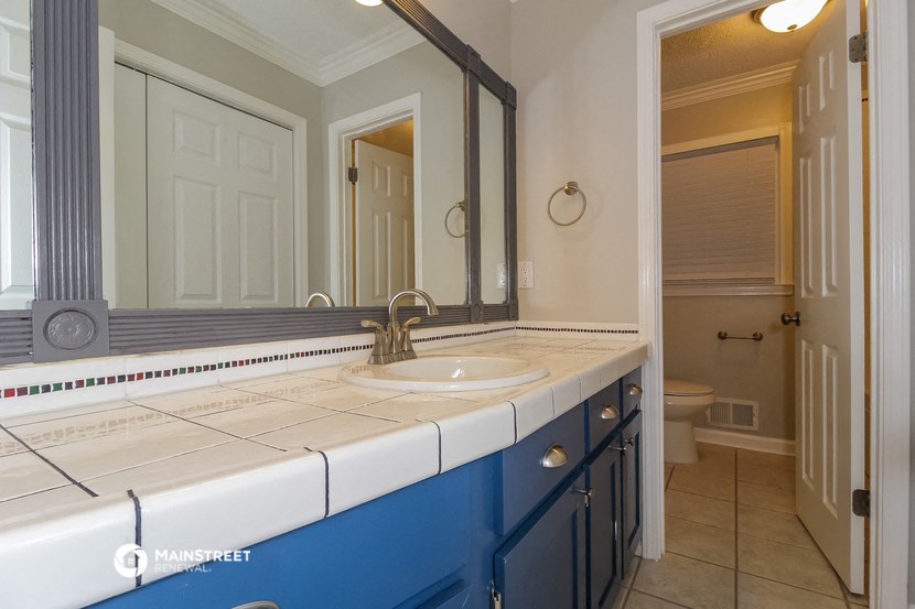 a blue and white bathroom with a sink and a mirror