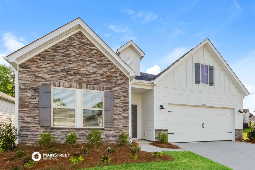 a white house with a stone facade and a white garage