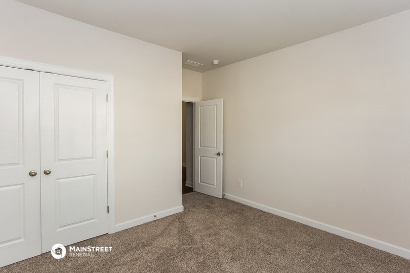 a bedroom with two closets and a door to a hallway