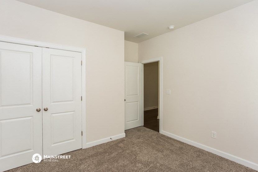 a bedroom with two closets and a door into a hallway
