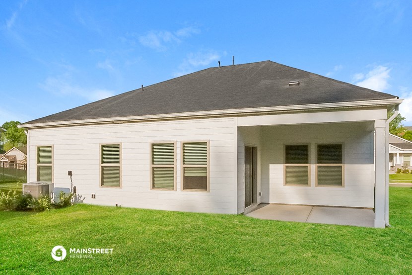 a white house with a gray roof on a lawn