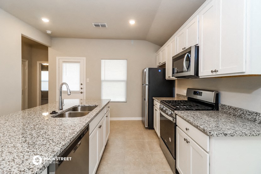 a kitchen with granite counter tops and stainless steel appliances